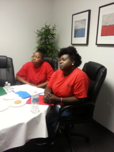Two black women in red on chairs