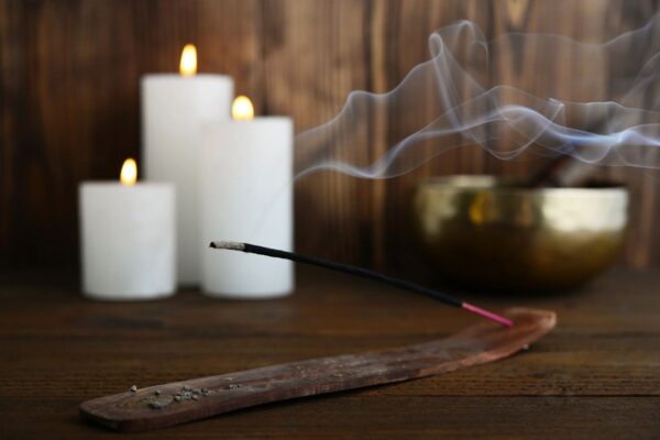 Indian incense stick, three candles and a bowl